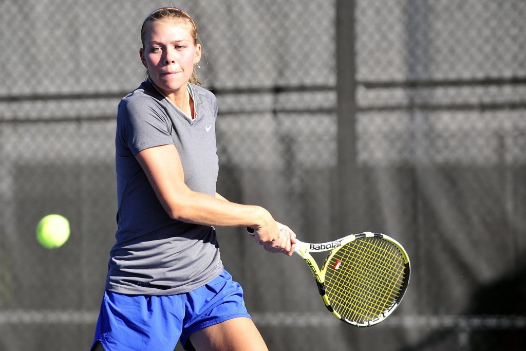 Tennis player using a racket with a dampener.